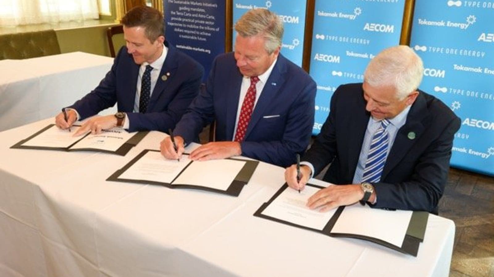 L.-r. Warrick Matthews, CEO, Tokamak Energy, Chris Mowry, CEO, Type One Energy and Troy Rudd, Chairman and CEO, AECOM, sign the UK Infinity Fusion Consortium.